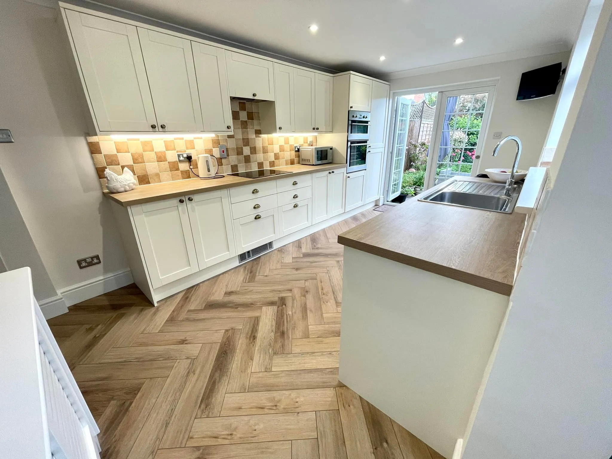 Kitchen with parquet flooring.
