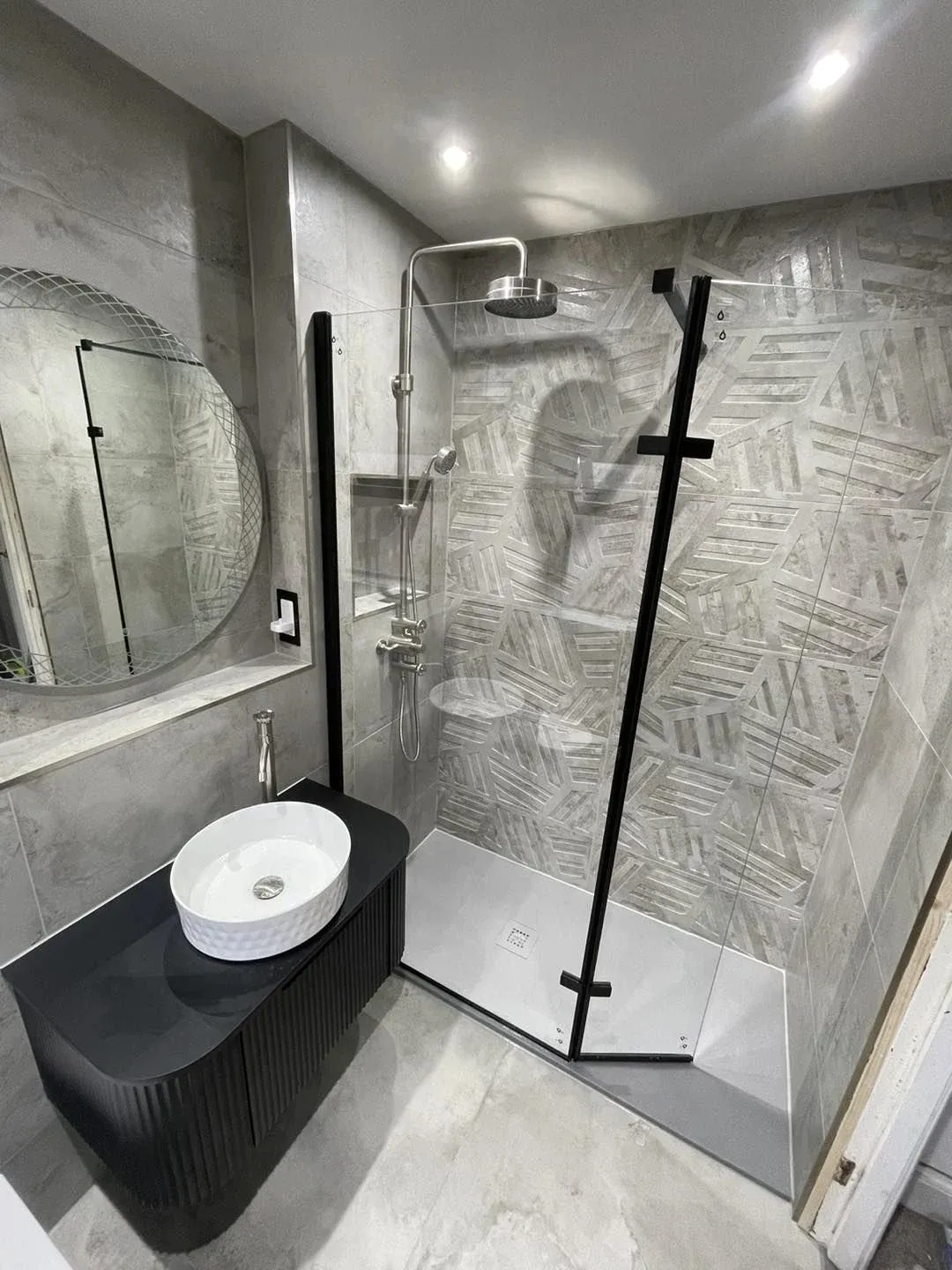 A bathroom with a stand up shower and a sink.