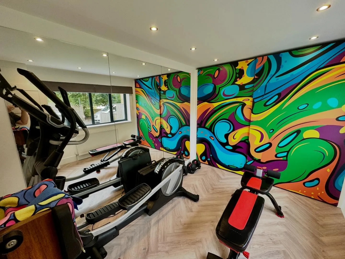 A gym with a colorful mural on the wall.