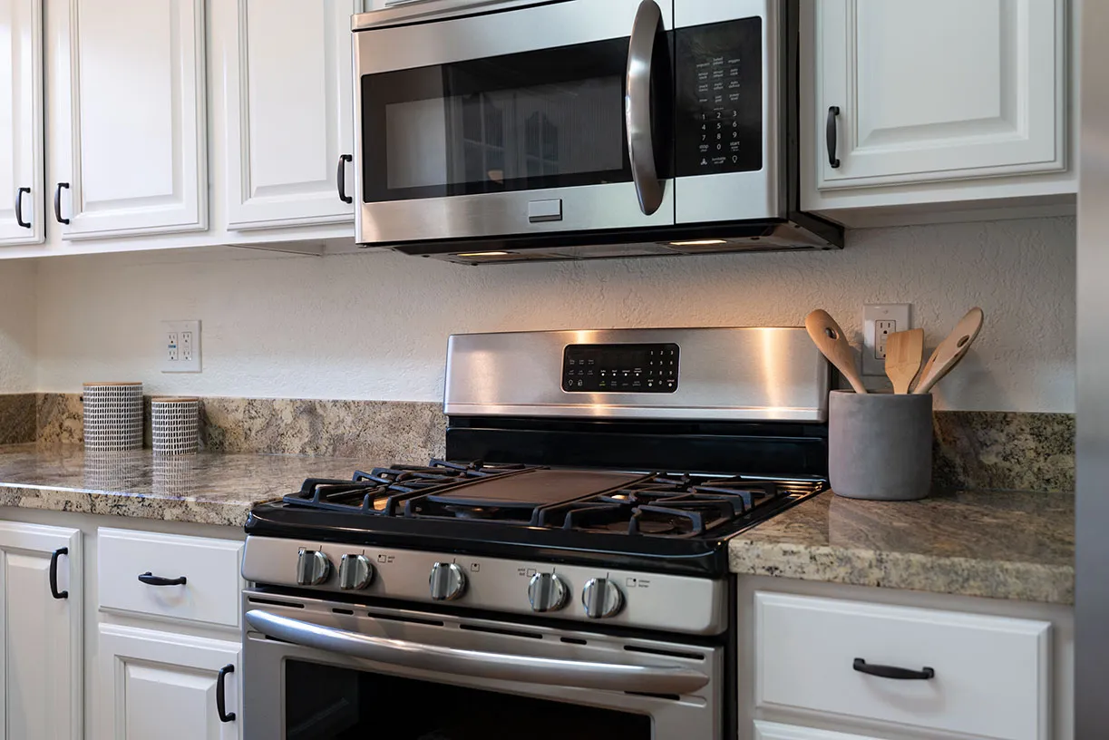 A stainless steel stove and microwave in a kitchen.