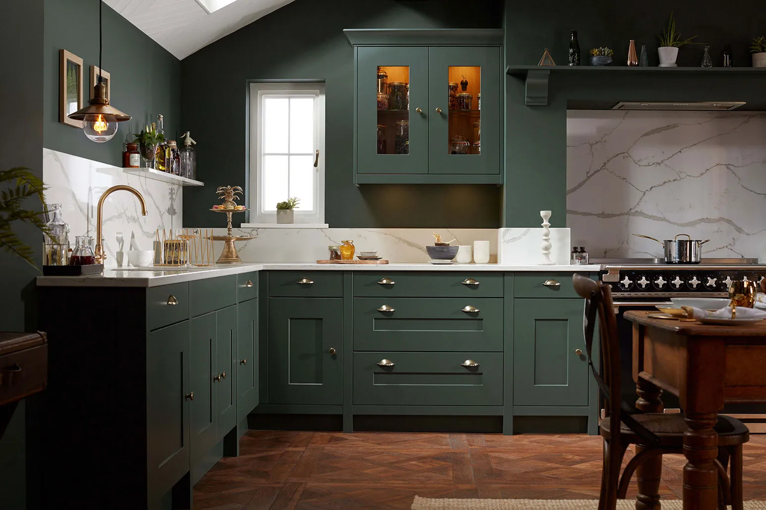 A kitchen with green cabinets and white counter tops.